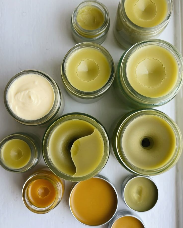 Hands pouring warm balm into a glass jar