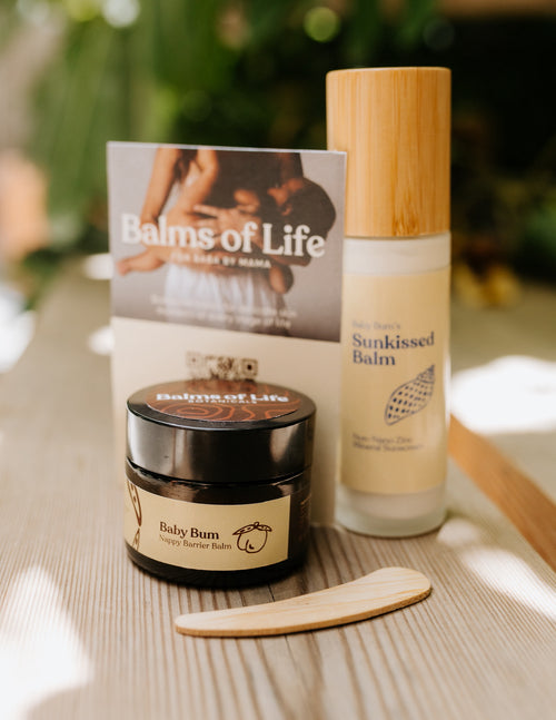 Baby Bum nappy barrier balm in an amber glass jar, next to Sunkissed Balm and a Balms of Life card